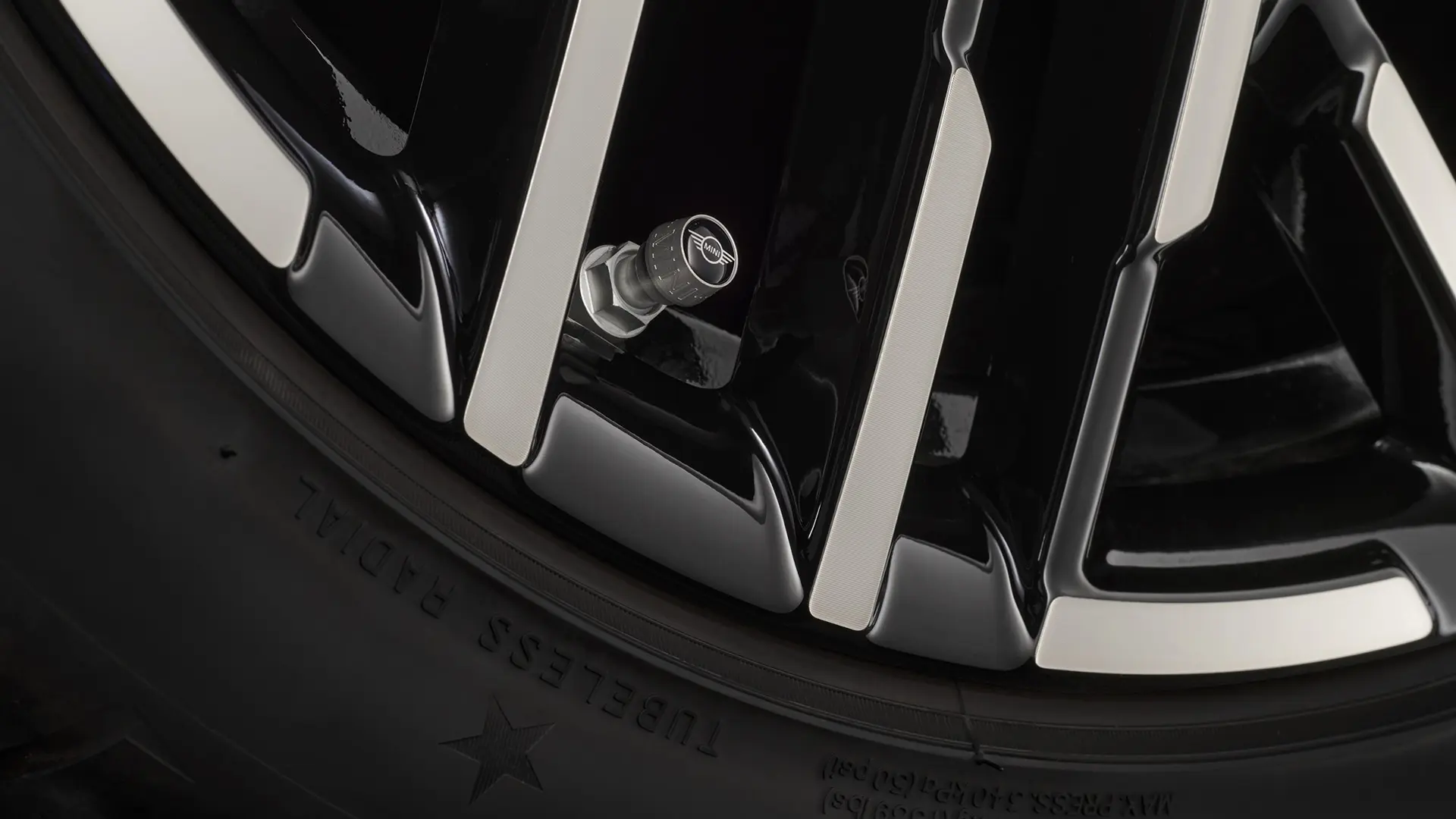 Close-up of black valve stem cap with the silver MINI wing logo.