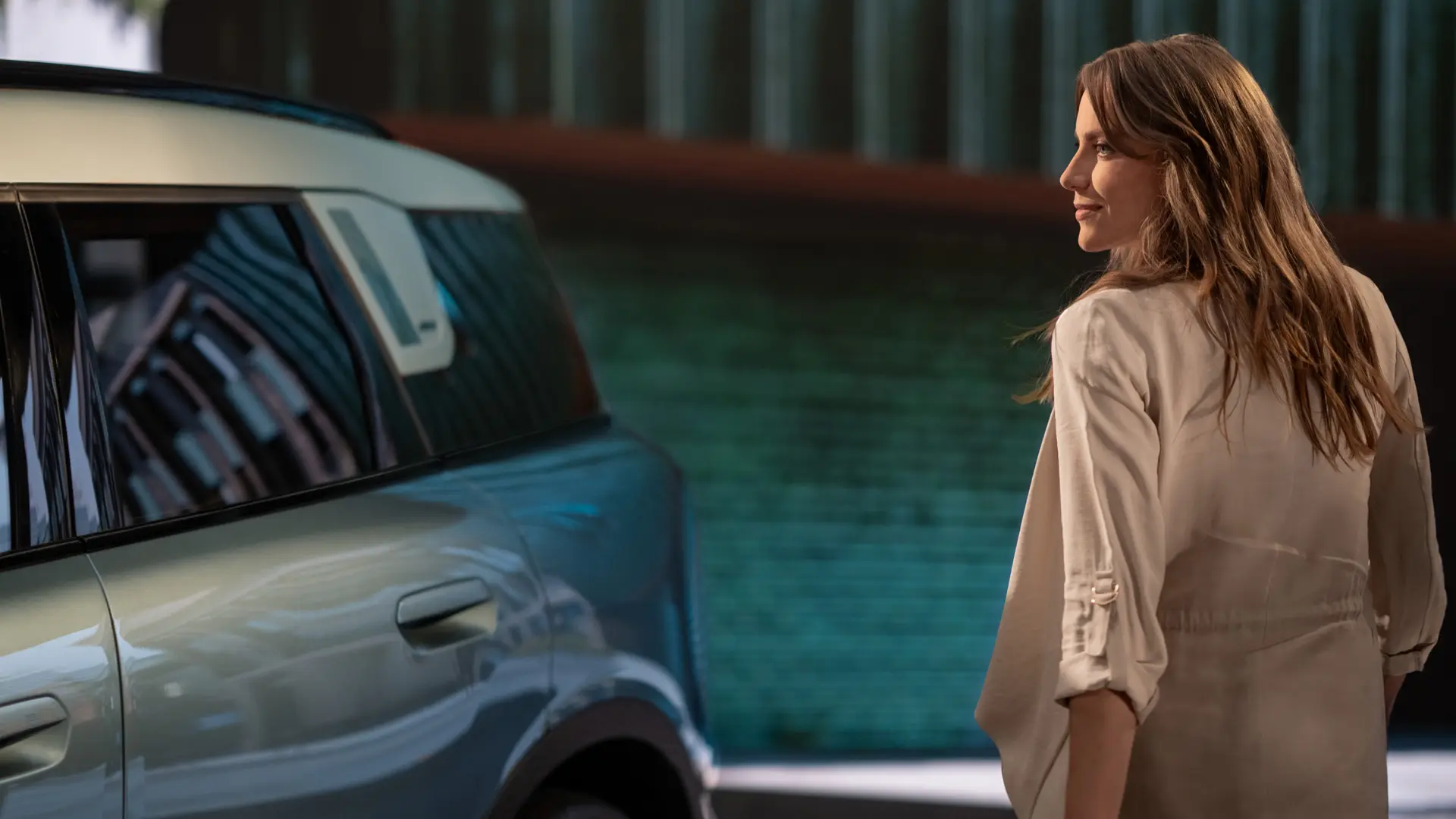 A woman standing next to a MINI