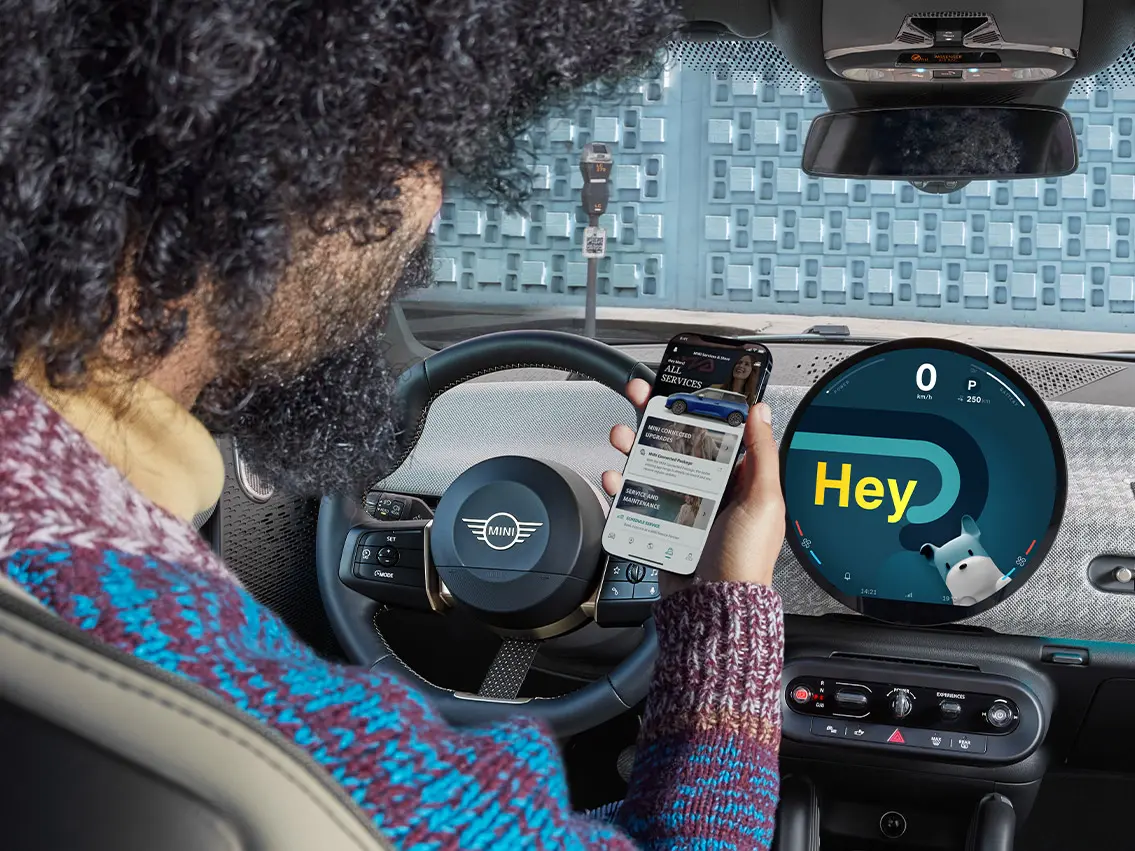 A man sitting in a MINI looking at his phone