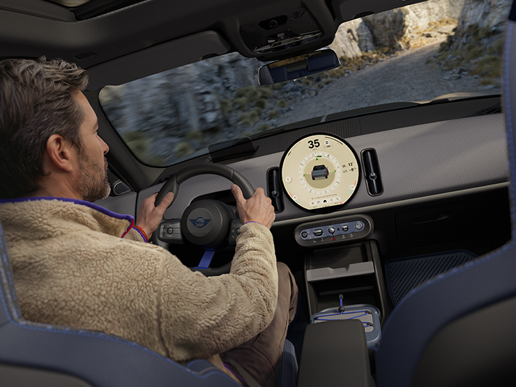 Image of two people driving in the MINI Countryman Untamed Edition with the Trail Mode on.