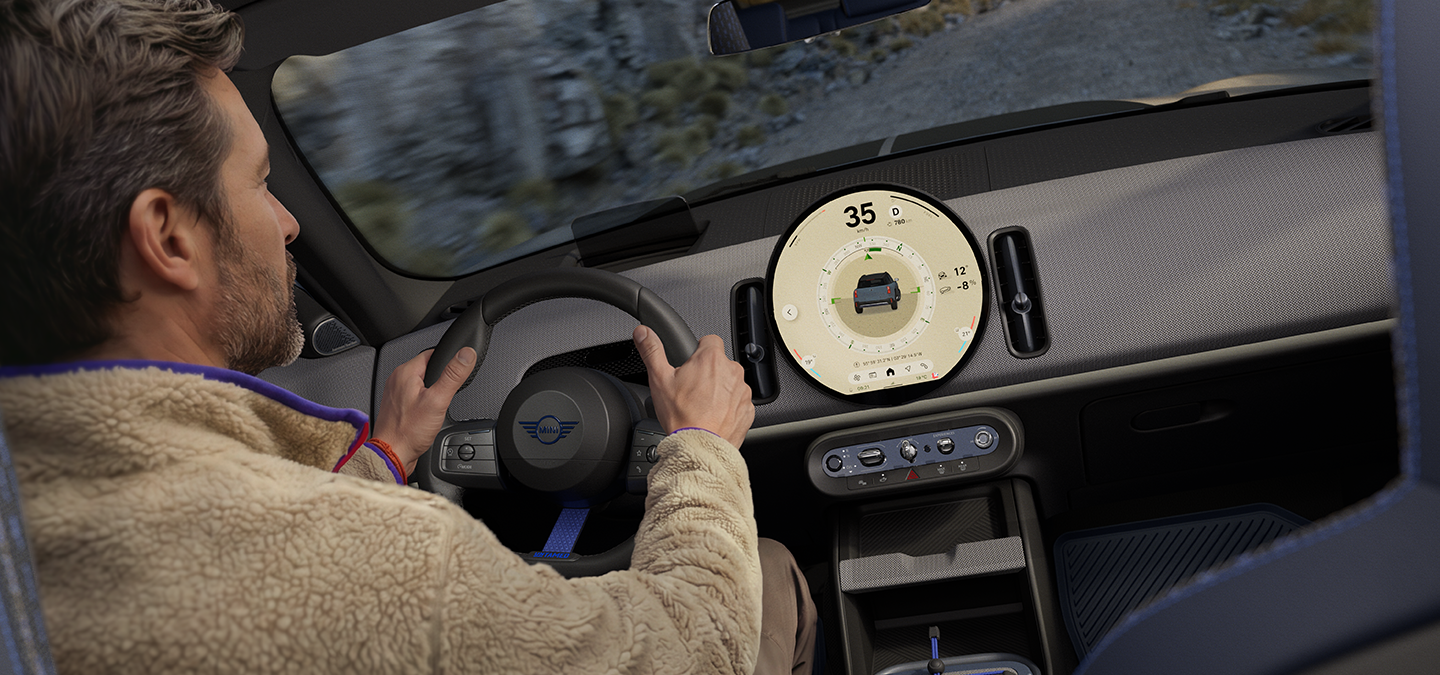Image of two people driving in the MINI Countryman Untamed Edition with the Trail Mode on.